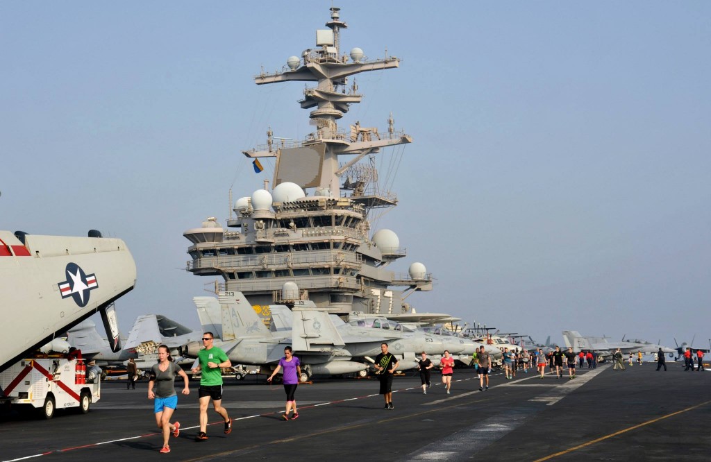 Sailors run on the flight deck aboard the aircraft carrier. (Photo: U.S. Navy photo by Mass Communication Specialist 3rd Class Margaret Keith)