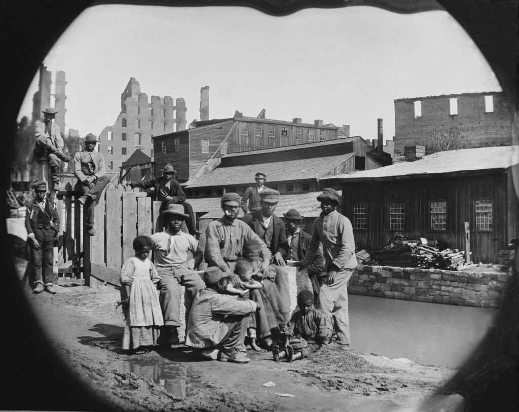 A newly freed African American group of men and a few children posing by a canal against the ruins of Richmond, Va.  Photo made after Richmond was taken by Union troops on April 3, 1865. (Photo: Everett Collection/Newscom)