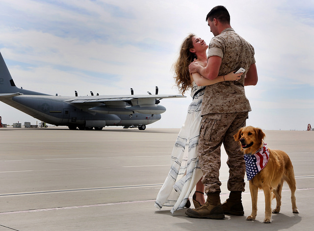Cpl. Daniel G. Dillender, airframes mechanic with Marine Aerial Refueler Transport Squadron (VMGR) 352, Marine Aircraft Group 11, 3rd Marine Aircraft Wing, is reunited with his wife, Angelica Dillender, and their dog Bella at Marine Corps Air Station Miramar, Calif. (Photo: Sgt. Keonaona C. Paulo/ Released)