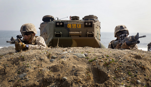 Marines wait for the command to advance after rushing out of a Republic of Korea Marine amphibious assault vehicle. (Photo: Lance Cpl. Cedric R. Haller II/Released)
