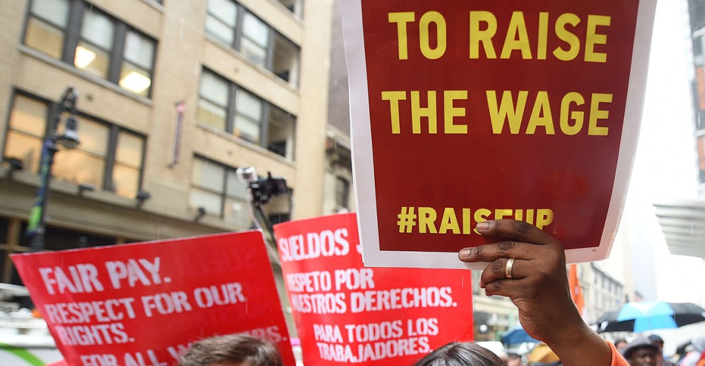 Fast-food workers hold placards in support to an increase of the fast-food workers minimum wage in New York, May 15, 2014.  (Photo: Emmanuel Dunand/Newscom)