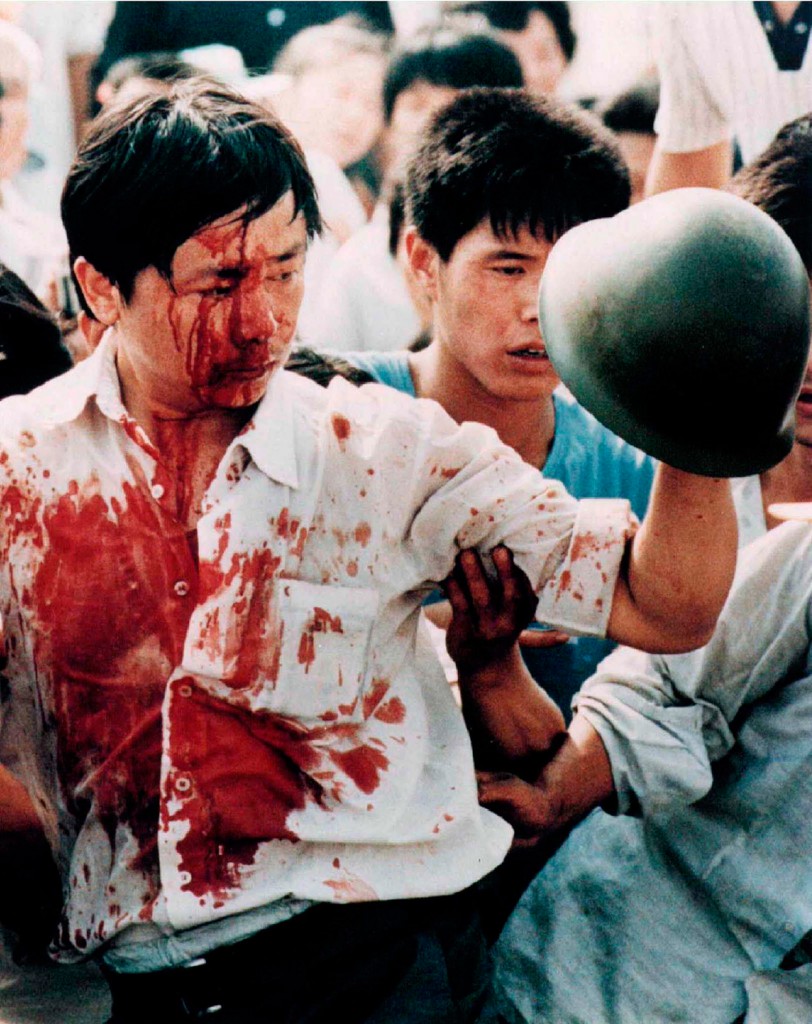 A blood-covered protester holds a Chinese soldier's helmet following violent clashes with military forces during the 1989 pro-democracy demonstrations in Beijing's Tiananmen Square. (Photo: STRINGER/REUTERS/Newscom)