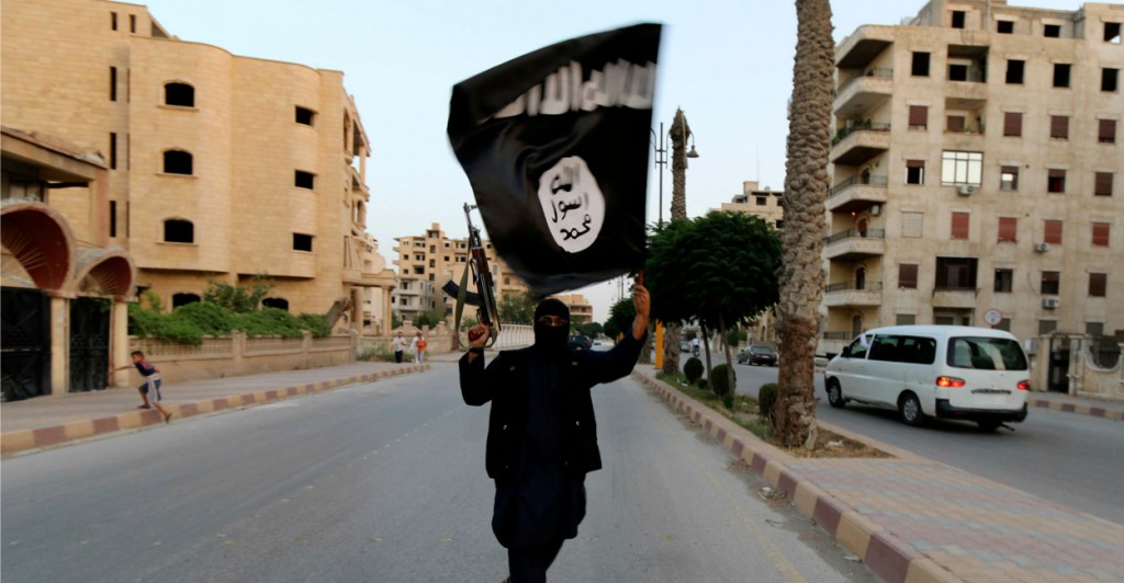 A member of ISIS waves its flag in Raqqa, Syria. (Photo:Stringer/Reuters/Newscom)