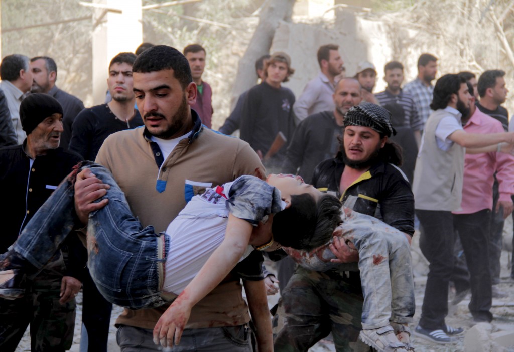 Men carry injured schoolchildren after what activists said was a barrel bomb dropped by forces loyal to Syria's President Bashar al-Assad and hit a school and a residential building in Seif al-Dawla neighborhood of Aleppo May 3, 2015. (Photo: SULTAN KITAZ/REUTERS/Newscom)