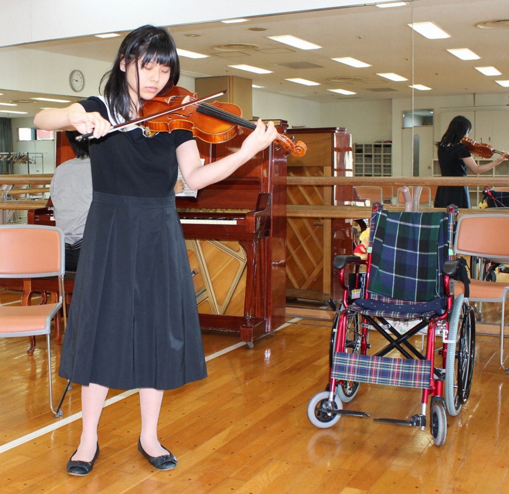 Yui Ito, a Japanese teenager, is a victim of the HPV vaccine Cervarix. In this photo from Oct. 12, 2013, she performs at an audition in Tokyo. Yui, who has suffered partial paralysis and pain since 2011, uses a wheelchair except when in bed, but  stands to play when performing. (Photo: Kyodo/Newscom)