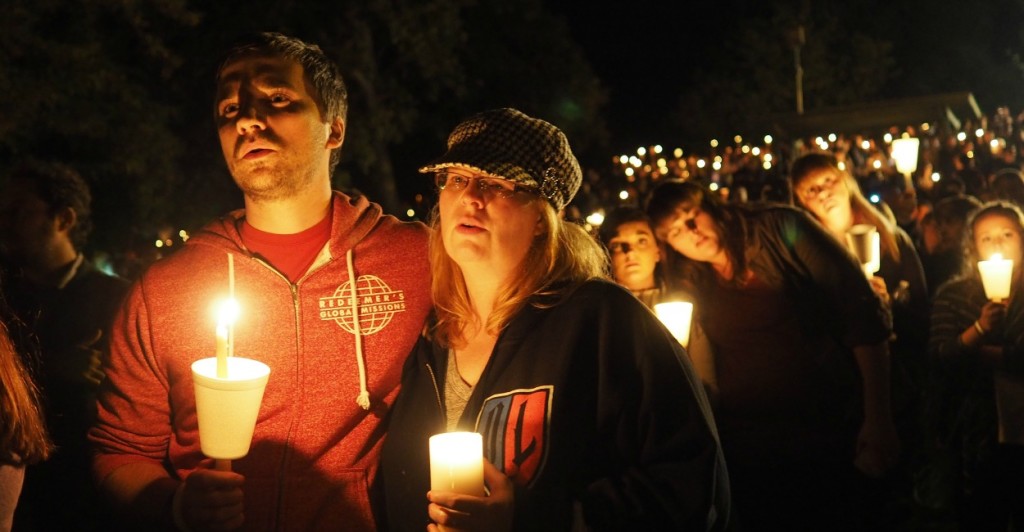 Pastor Grant Goins and Rosemary Alwan sing along to 'Amazing Grace' during a candlelight vigil, held Thursday, October 1, 2015 in Roseburg, Oregon, for the victims of the mass shooting. (Photo: Amiran White/ZUMA Press/Newscom)