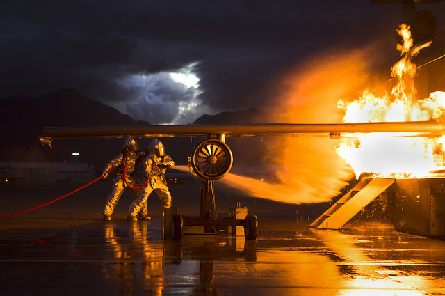 Marines with Aircraft Rescue and Fire Fighting douse flames engulfing a mobile aircraft firefighting training device as a part of night time 360 degree firefighter training aboard Marine Corps Air Station Kaneohe Bay. (Photo: Cpl. Matthew Callahan/Released)