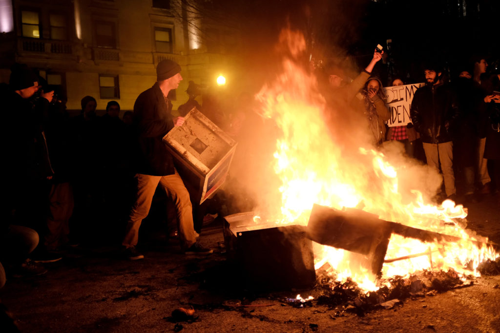 Protesters burn trash and newspaper dispensers in the road outside the offices of The Washington Post. (Photo: James Lawler Duggan/Reuters/Newscom)