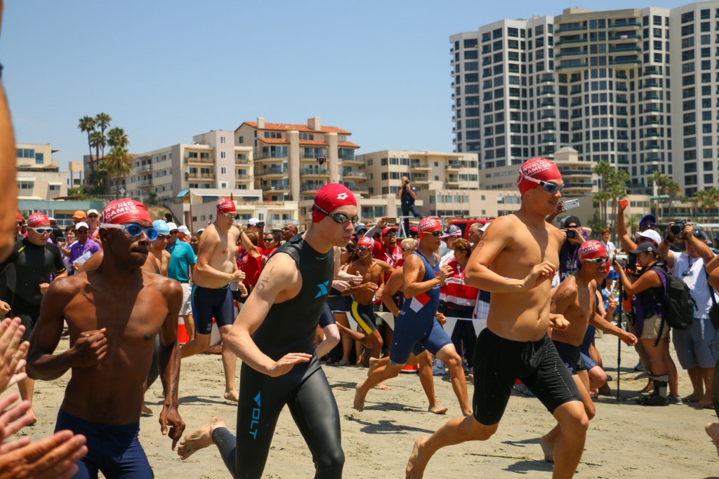 The group of athletes run from the beach into the water to compete in a swimming competition. (Photo: Flickr/SpecialOlympicsUSA)
