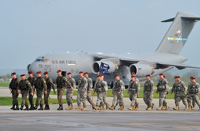Polish soldiers (L) accompany US Airborne soldiers upon their arrival at the military airport in Swidwin, northern Poland, 23 April 2014. An US Army company of about 150 soldiers from the 173rd Airborne Brigade Combat Team based in Vicenza, Italy, came for military exercises in Poland due to the political situation in Ukraine. The exercises, involving some 600 troops, also take place in Estonia, Latvia and Lithuania, and is scheduled to last for about a month. (Photo: MARCIN BIELECKI/EPA/Newscom)