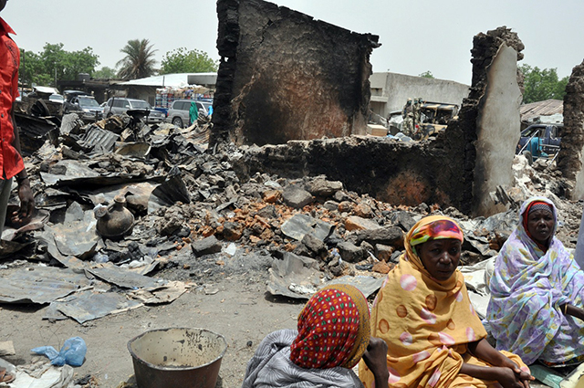Women sit at Gamboru central market burnt by suspected Boko Haram. (Photo: Newscom/Getty Images)