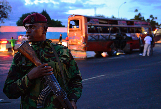 A Kenyan policeman stands in front of the wreckage of a bus at the site of a bomb blast in Nairobi on May 4, 2014. (Photo: CARL DE SOUZA/AFP/Getty Images/Newscom)