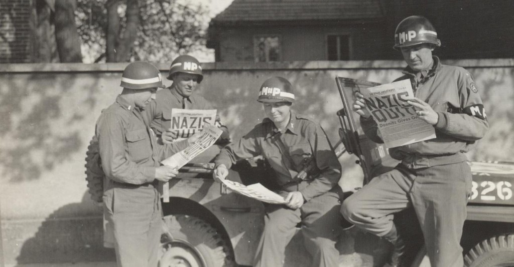US military policemen read about the German surrender in the newspaper ‘Stars and Stripes.’ (Photo: US Army/Public Domain)