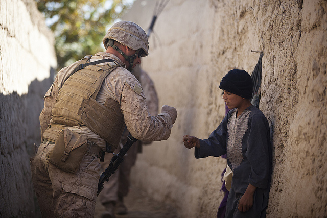 U.S. Marine Lance Cpl. Dominic Evola, a 29-year-old rifleman with Jump Platoon, Headquarters and Service Company, 3rd Battalion, 3rd Marine Regiment, from Medford, N.J., greets an Afghan boy by “pounding fists." (Photo: Cpl. Reece Lodder)