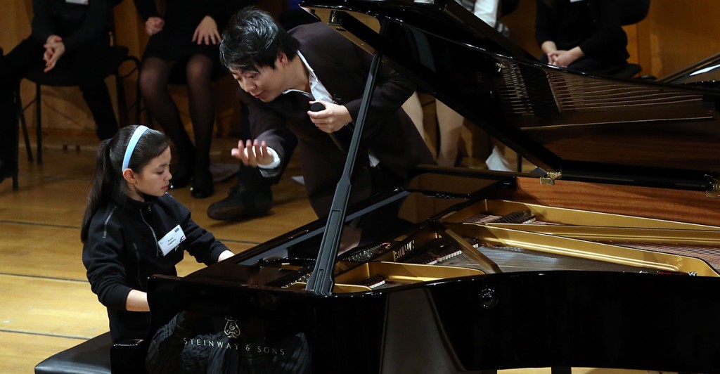 Avery receives lessons from starpianist Lang Lang during the Junior Music Camp in Munich. (Photo: Newscom)