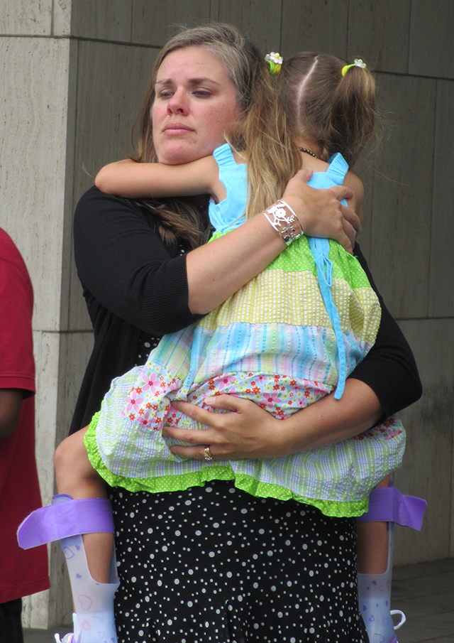 Carrie Pratt holds daughter Dagen, then 6, at a news conference last August outside HHS headquarters.  (Photo: Angela Bradbery/Public Citizen)