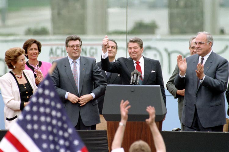Reagan at podium with a thumbs up with German Chancellor Helmut Kohl, German political leader Philipp Jenninger and his wife. (Photo: Ronald Reagan Library)