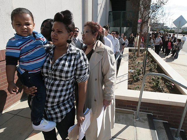 Crystal Caballero, who said she needs a job so she can get off welfare, holds her son, 2 1/2-year-old Lah-Johndre (cq) Pardue, as she waits in line outside Chukchansi Park to apply for seasonal work. / © Eric Paul Zamora/The Fresno Bee/ZUMAPRESS.com