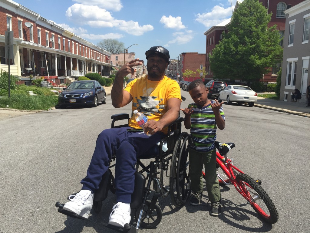 Shakeebe McKoy, an East Baltimore resident visiting his family in West Baltimore, imparts a "realistic" brand of parenting on his young son, Craig. (Photo: Josh Siegel/The Daily Signal)