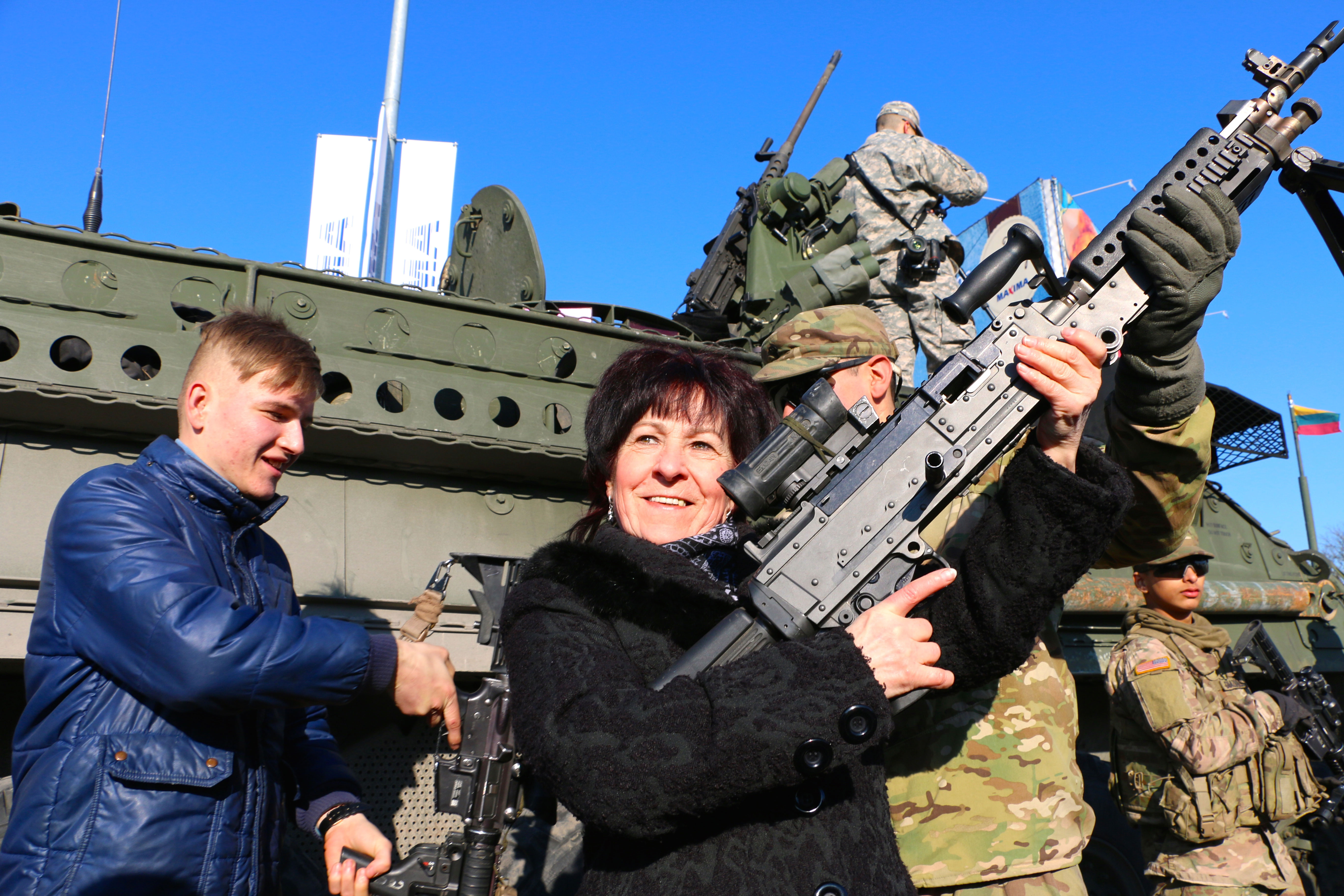A woman in Lithuania greets U.S. Army soldiers.