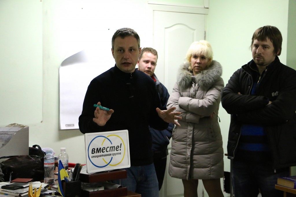 Peter Andrushchenko (left) and Maksim Borodin (far right) leading a discussion on democracy in a Mariupol basement. (Photo: Nolan Peterson/The Daily Signal)