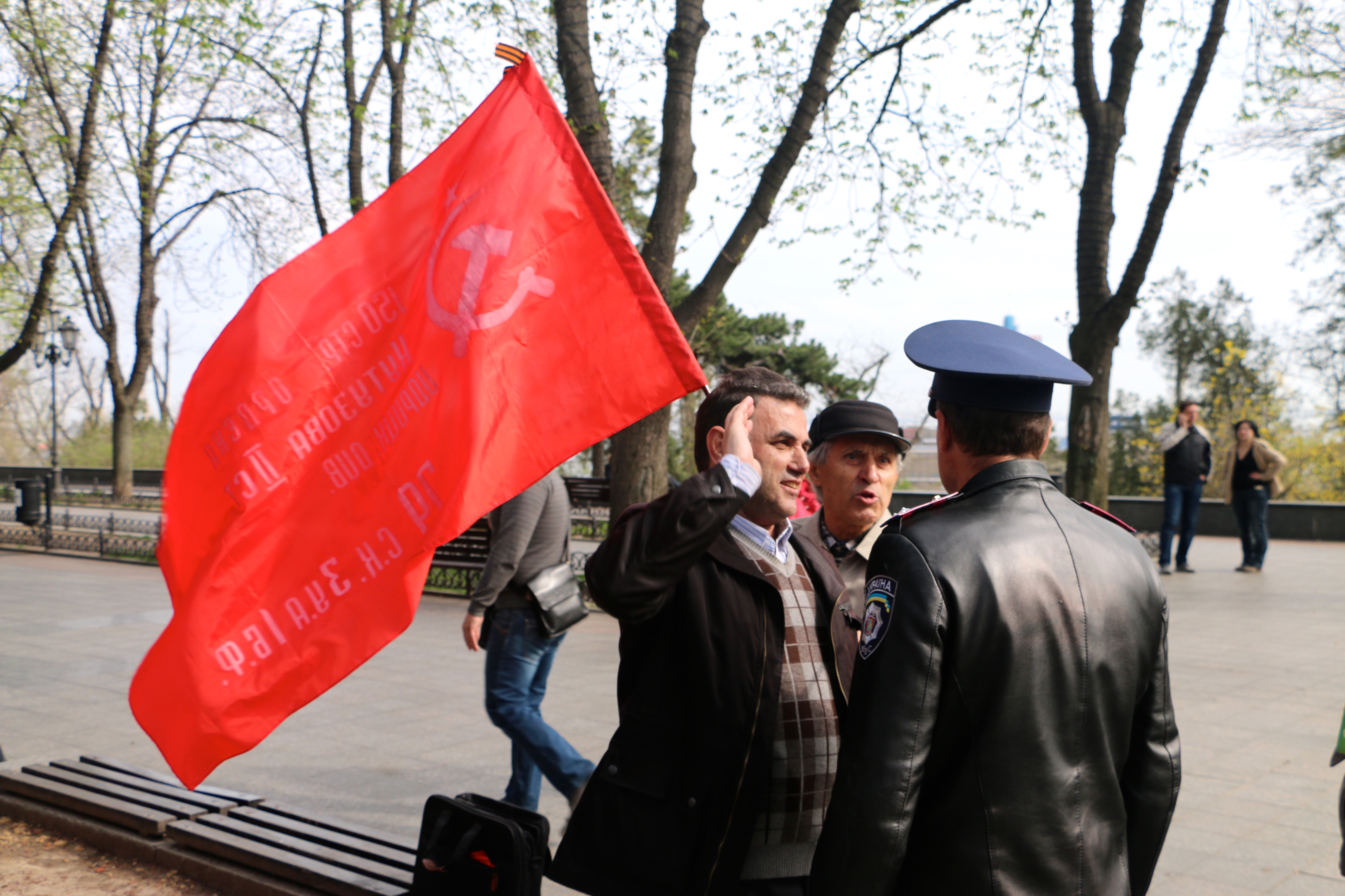 A police officer tells Communist Party members to put away a Soviet flag in Odessa, Ukraine. (Photo: Nolan Peterson/The Daily Signal)