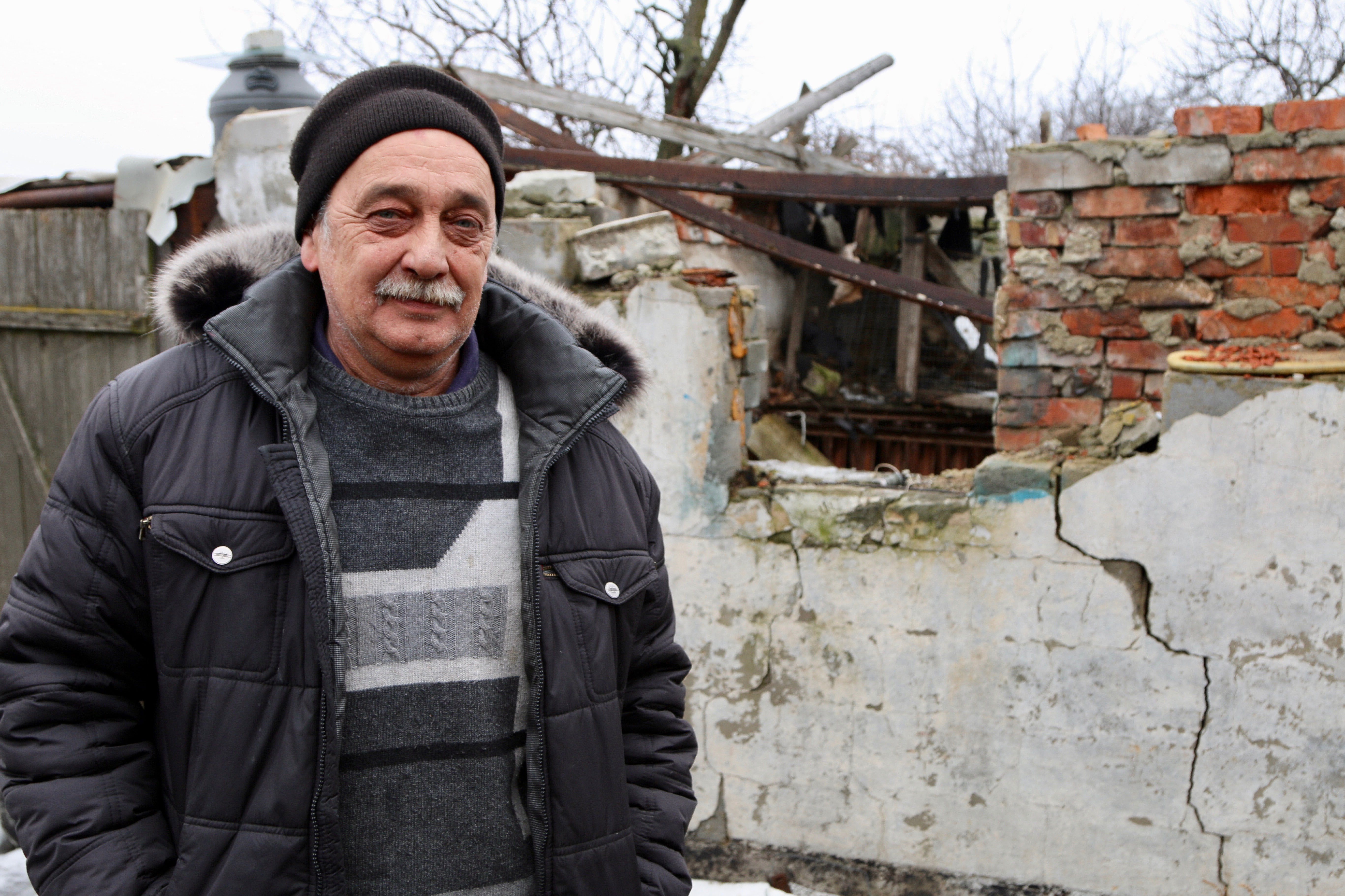 Valera Dudochkin, 53, a Russian, stands before his artillery-damaged home in eastern Ukraine. (Photos: Nolan Peterson/The Daily Signal)