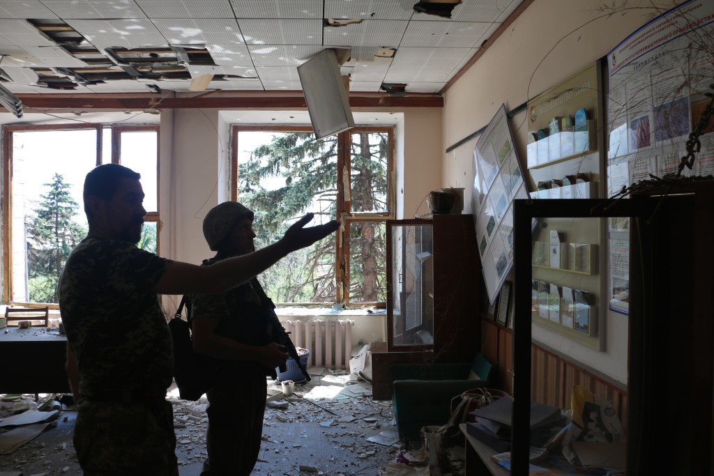 Ukrainian soldiers surveying damage at a school in Pisky. (Photo: Nolan Peterson/The Daily Signal)