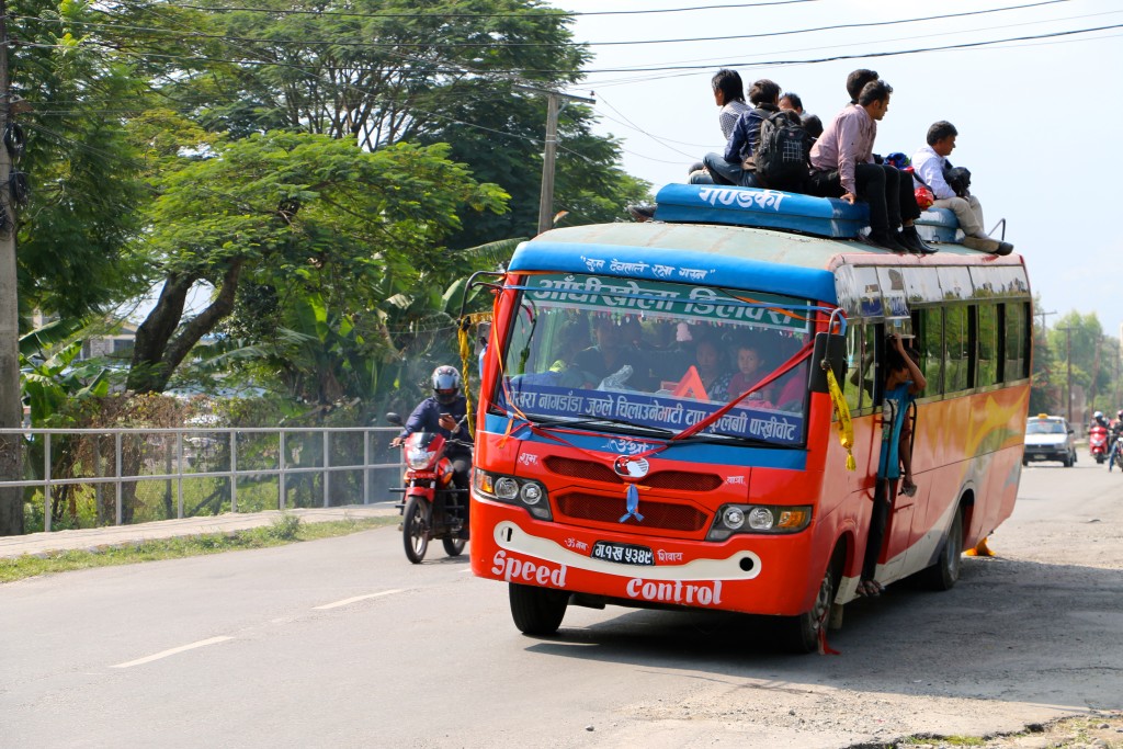 Many in Nepal ride on the roofs of buses when seats inside fill up. (Photo: Nolan Peterson/The Daily Signal)