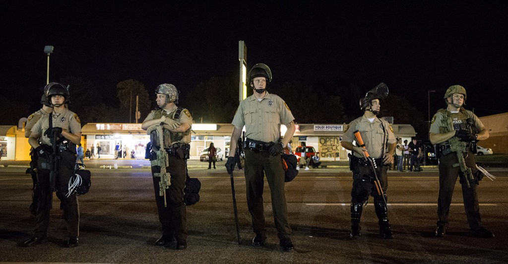 Police officers in riot gear stand guard during a protest in Ferguson. (Photo: Xinhua/Ting Shen)