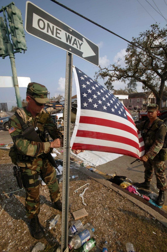 Two members of the National Guard put up the American flag amidst the rubble of the storm. (Photo: Haley/SIPA/Newscom)