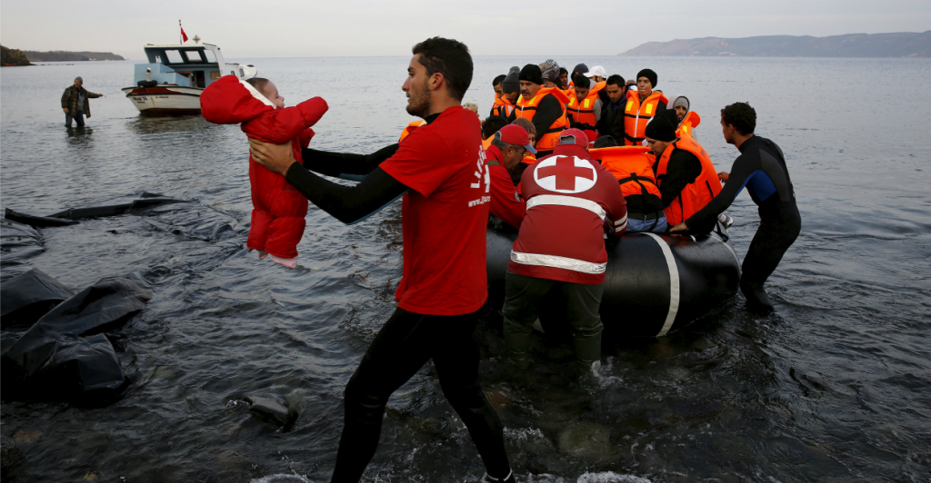 A Red Cross volunteer carries a Syrian refugee baby off a raft at a beach on the Greek island of Lesbos on Nov. 16. (Photo: Yannis Behrakis/Reuters/Newscom)