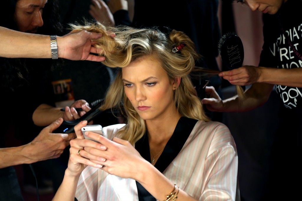 Model Karlie Kloss gets her hair and make up done prior to the show. (Photo: Hugo Philpott/Newscom)