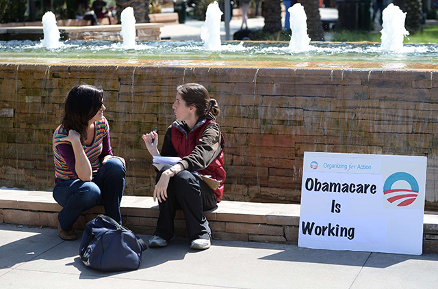 An ACA supporter (R) talks with a student (L) about Obamacare on the campus of Santa Monica City College in Santa Monica, California in October 2013. (Photo: Robyn Beck/AFP/Getty Images/Newscom)