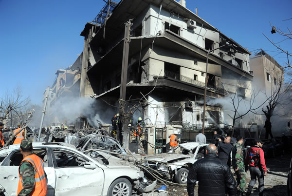 A handout picture released by the official Syrian Arab News Agency (SANA) on March 17, 2012, shows fire fighters at the scene following a two bomb attacks on security buildings in the heart of the Syrian capital Damascus which killed several people, state television said. AFP PHOTO/HO