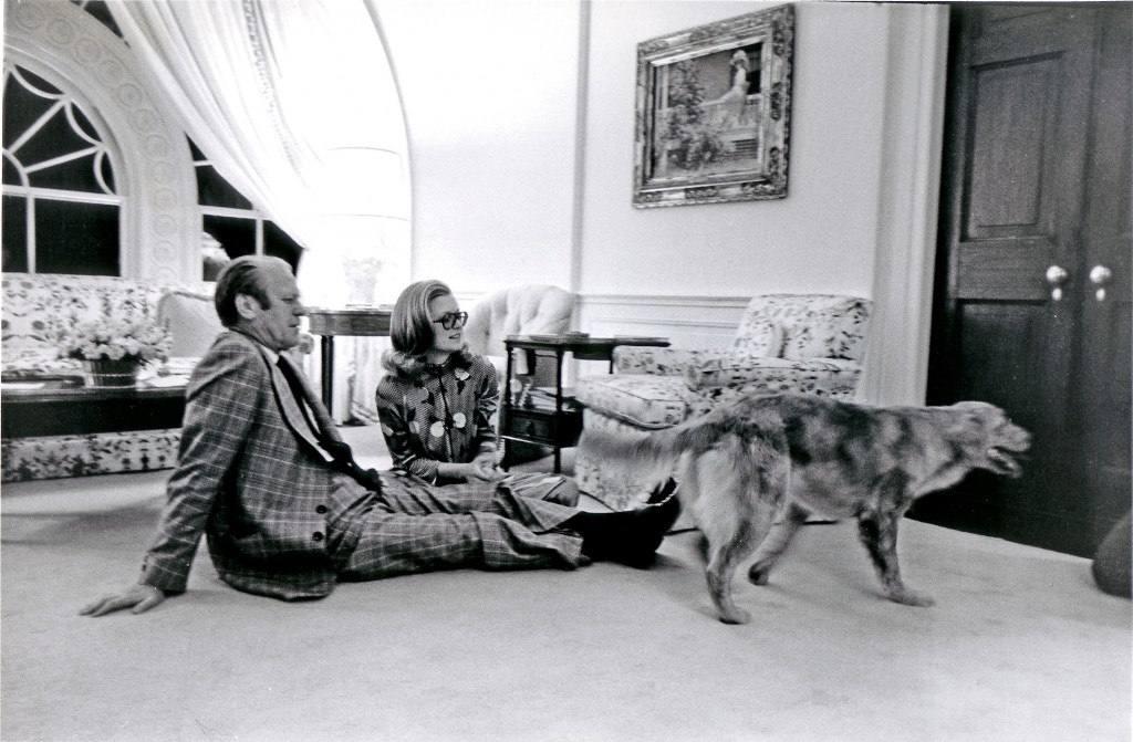 President Gerald R. Ford and his daughter, Susan Ford, sit on the floor of the Great Hall in the private area of the White House with their golden retriever Liberty. (Photo: Newscom)