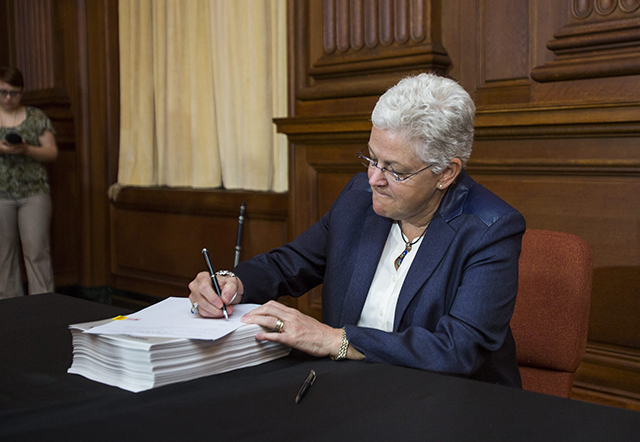 EPA administrator Gina McCarthy signs President Obama's new carbon pollution emission guideline plan at EPA headquarters in Washington, DC, USA, 02 June 2014. The plan, which bypasses Congress, calls for a 30 percent cut in carbon emissions by 2030.  (Photo: Newscom)