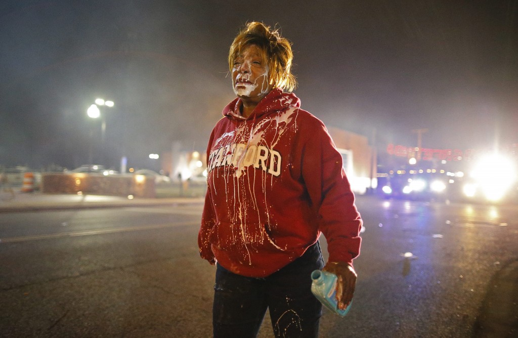 A protestor walks down the street after getting tear gas in her face. (Photo: Larry W. Smith/Newscom)