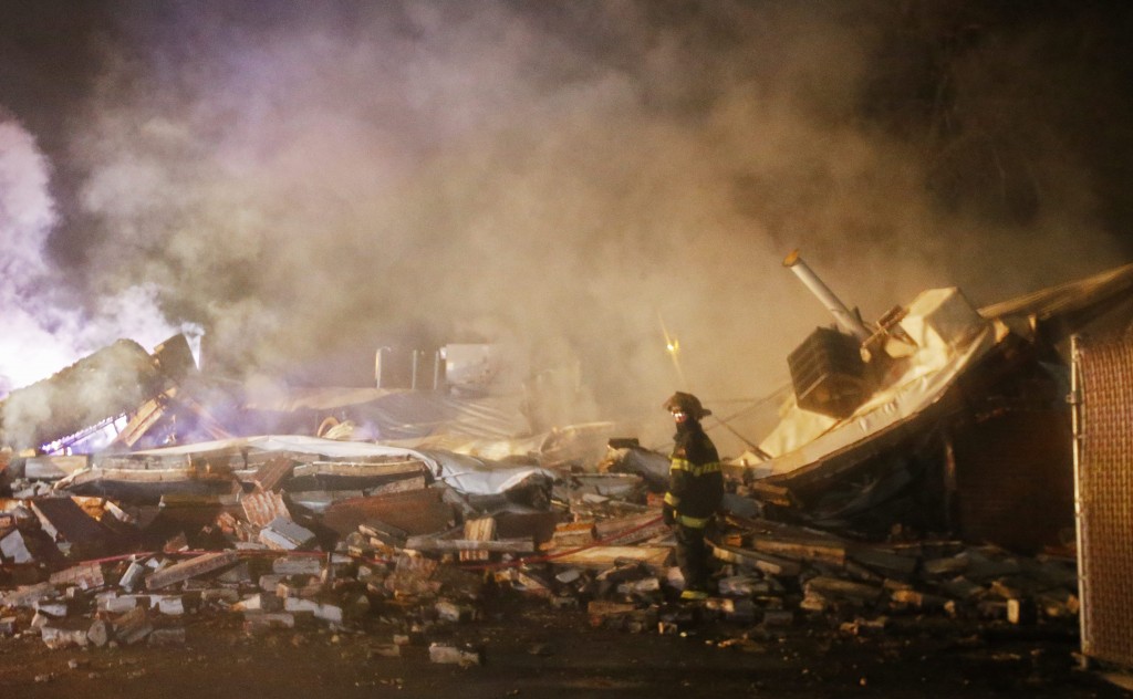 A firefighter stands next to smoking rubble after protesters burned more buildings. (Photo: Larry W. Smith/Newscom)