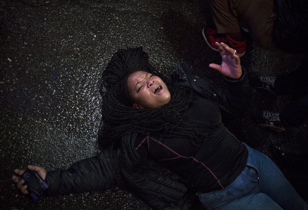 A protestor lies down on the street's pavement as they block the traffic on 42nd Street in Times Square during a protest against the decision of a grand jury not to indict a police officer involved in the death of Eric Garner. (Photo: John Taggart/Newscom) 