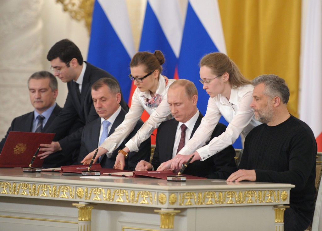Russian President Vladimir Putin with head of Crimean government Sergei Aksionov, chairman of Crimean parliament Vladimir Konstantinov, and head of Sevastopol city administration Alexei Chaliy sign the act of reunification Crimea with Russia in the Grand Kremlin Palace March 18, 2014. (Photo: EPA/Alexey Druzhinyn/Newscom)