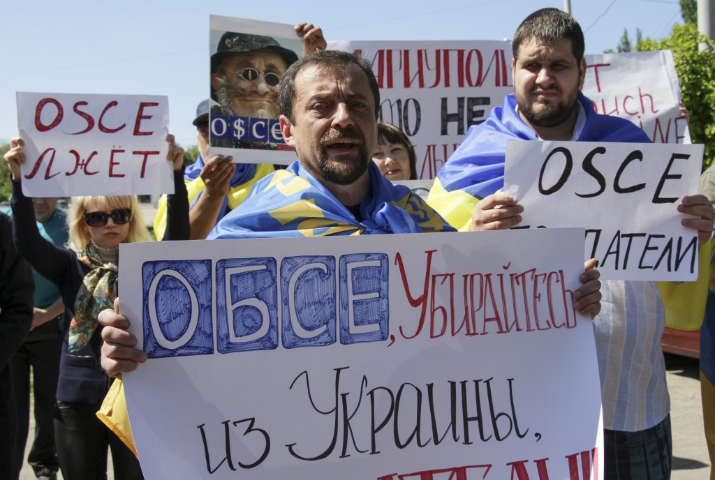People hold placards reading 'OSCE go out from Ukraine' and 'OSCE lies' as they protest against activities of Organization for Security and Cooperation in Europe (OSCE) in eastern Ukraine. (Photo: IRINA GORBASYOVA/EPA/Newscom)