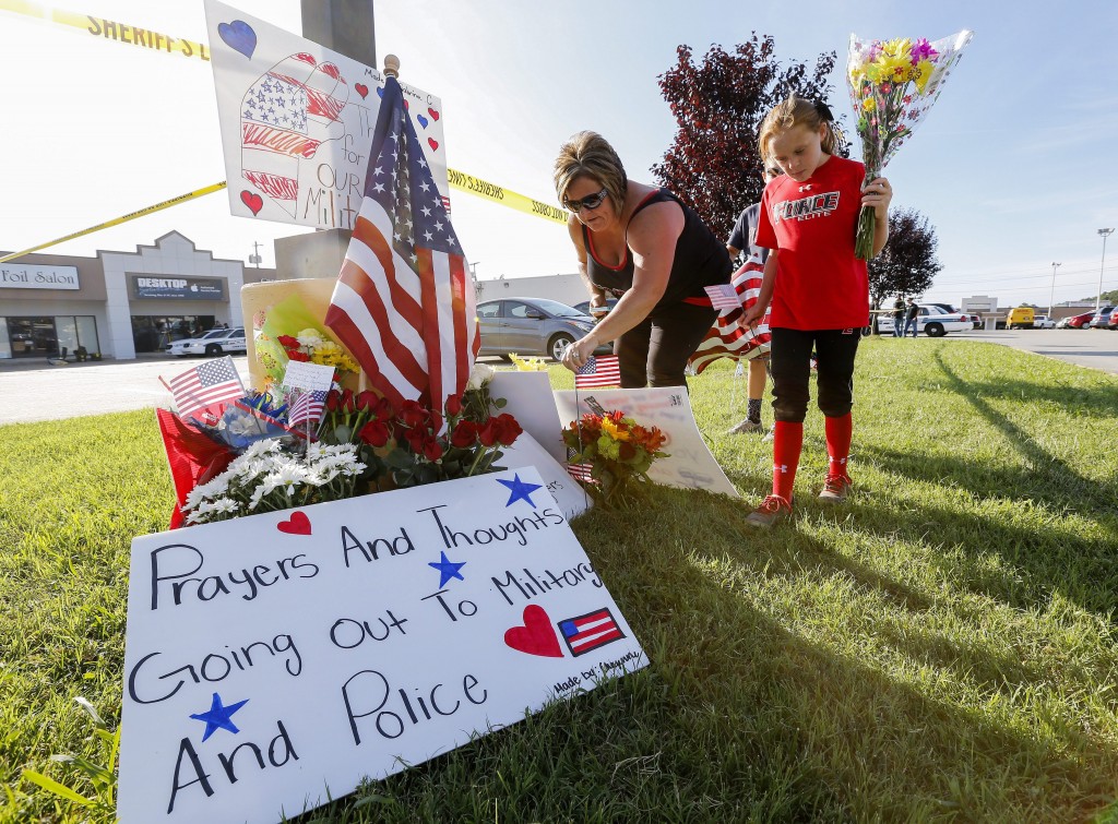 epa04849689 A family brings flowers to a makeshift memorial near a US Military Recruiting storefront after a shooting in Chattanooga, Tennessee, USA, 16 July 2015. Authorities say the shootings at two different locations left four US Marines and the gunman Mohammod Youssuf Abdulazeez dead.  EPA/ERIK S. LESSER (Newscom TagID: epalive751891.jpg) [Photo via Newscom]