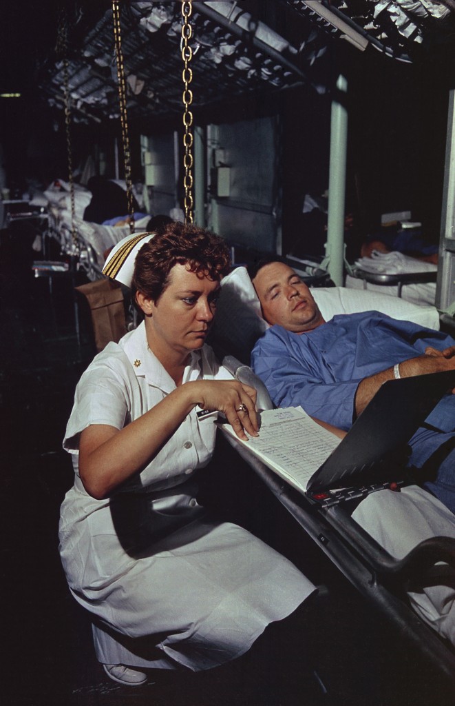 Lieutenant Commander Dorothy Ryan, an Navy Nurse aboard the hospital ship USS Repose off South Vietnam, checks a wounded soldier's medical chart. April 4, 1966. (Photo: evhistorypix/Newscom)
