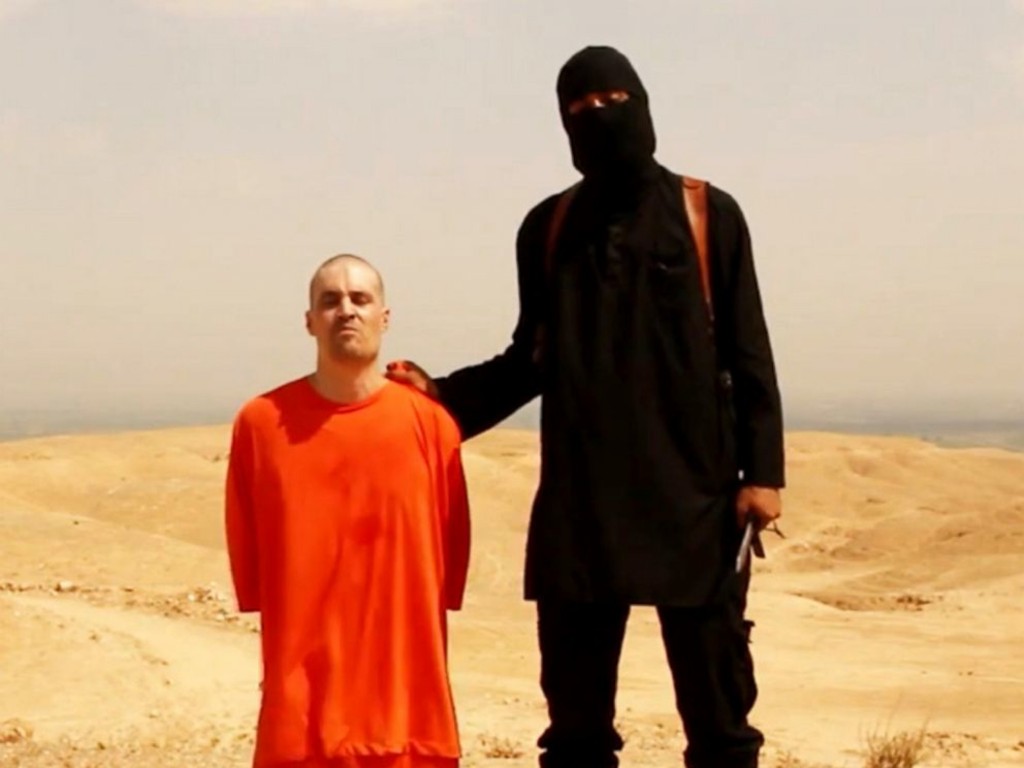 A videograb shows a masked ISIS militant holding a knife speaks next to U.S. journalist James Foley. (Photo: Newscom)