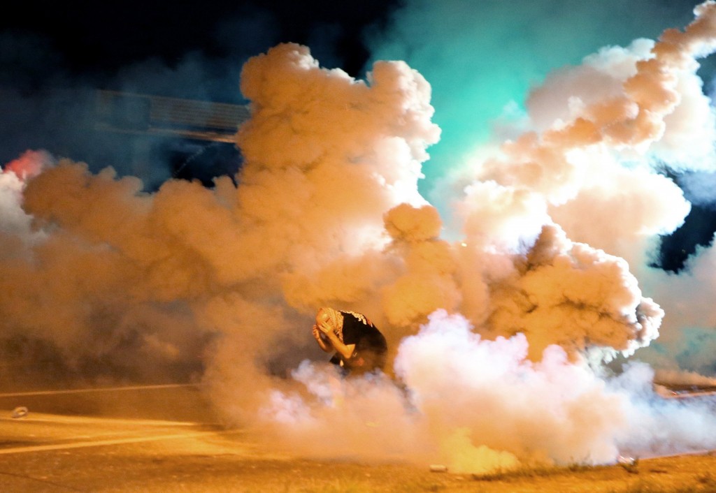 During the fourth night of unrest, a rotester takes shelter from the tear gas exploding around him. (Photo: David Carson/St. Louis Post-Dispatch/MCT)