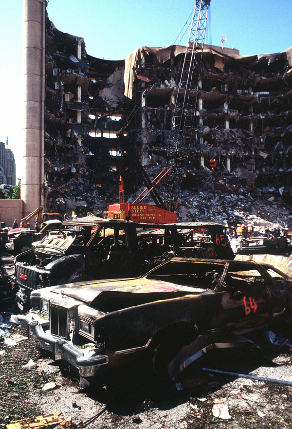 The remains of automobiles with the destroyed Federal Building in the background two days after the bombing. (Photo: Staff Sergeant Preston Chasteen/U.S. military or Department of Defense)