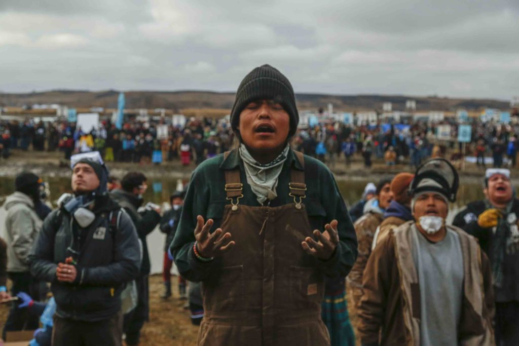 During a Nov. 23 protest against the Dakota Access pipeline, Frankie Tso Jr. prays amongst other demonstrators at the foot of a hill off the Missouri River surrounding the Standing Rock Indian Reservation. (Photo: Natasha Dangond/Polaris/Newscom)
