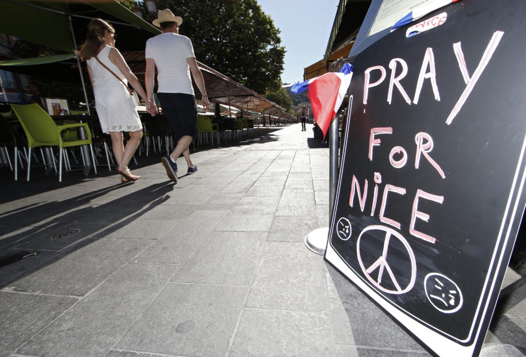 A couple walk through the empty flower market in the old city and near a sign which reads, "Pray for Nice" days after a truck attack on the Promenade des Anglais on Bastille Day killed scores and injured as many in Nice, France, July 17. (Photo: ERIC GAILLARD/REUTERS/Newscom)