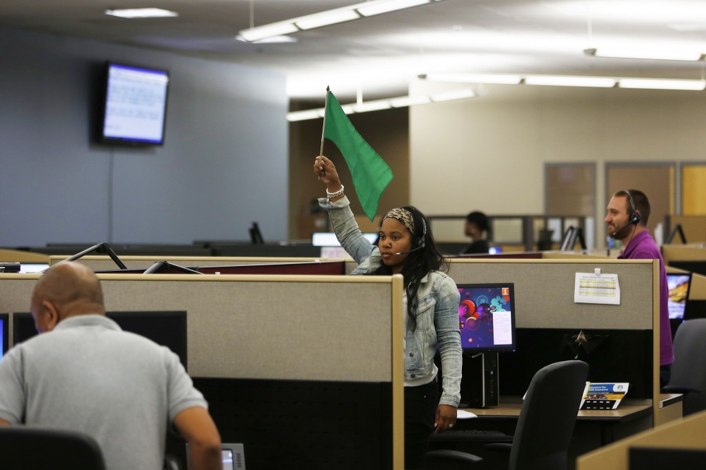 A customer service agent at Covered California's Concord call center waves a flag for technical assistance during the opening day of enrollment of the Patient Protection and Affordable Care Act in Concord, California October 1, 2013. (Photo: Stephen Lam/Newscom)